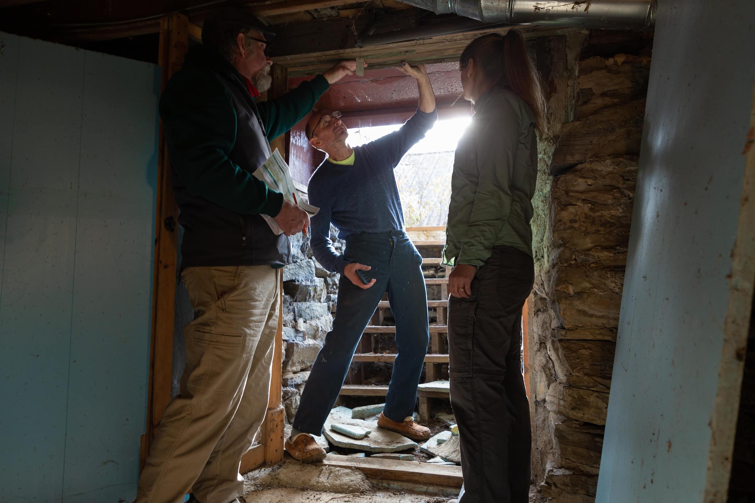 Evergreen Home Performance team inspecting an old, musty basement