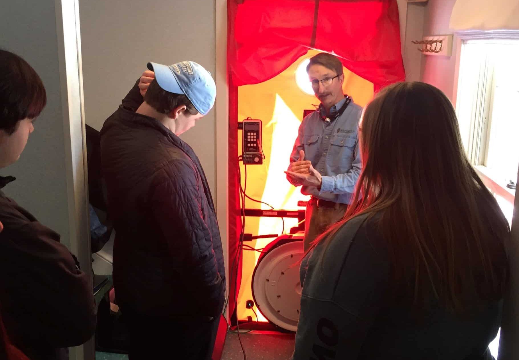 466395712_9572259509470187_4312171785185878963_n Evergreen Energy Advisor, Brian Robinson walking through a blower door test with a group of people in a house