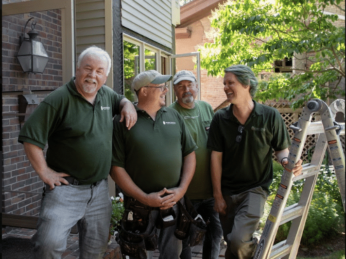 Evergreen Home Performance Team Smiling At A House While Working