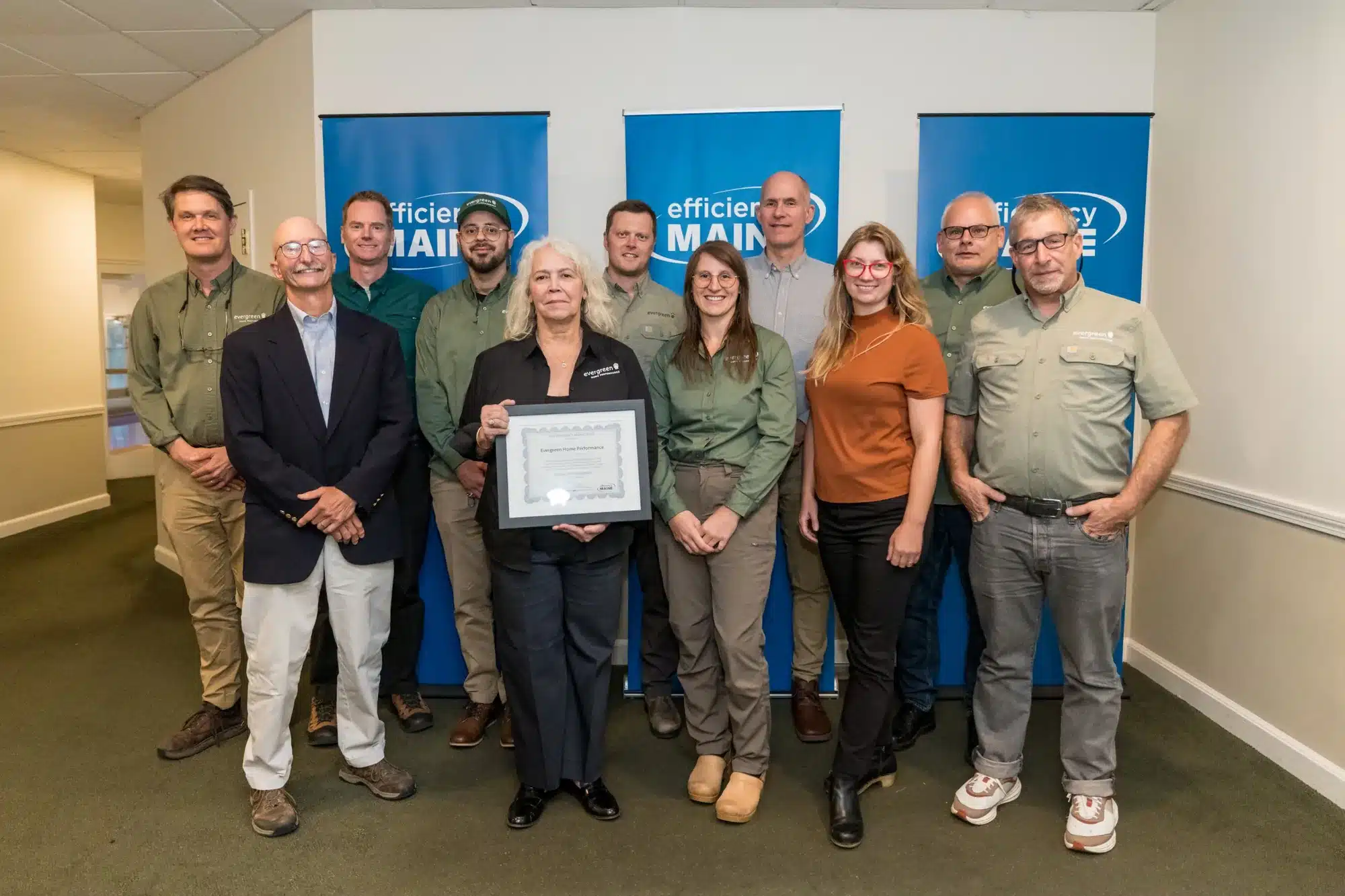 The Evergreen Home Performance team with Efficiency Maine staff holding the 2026 Efficiency Maine recognition certificate.