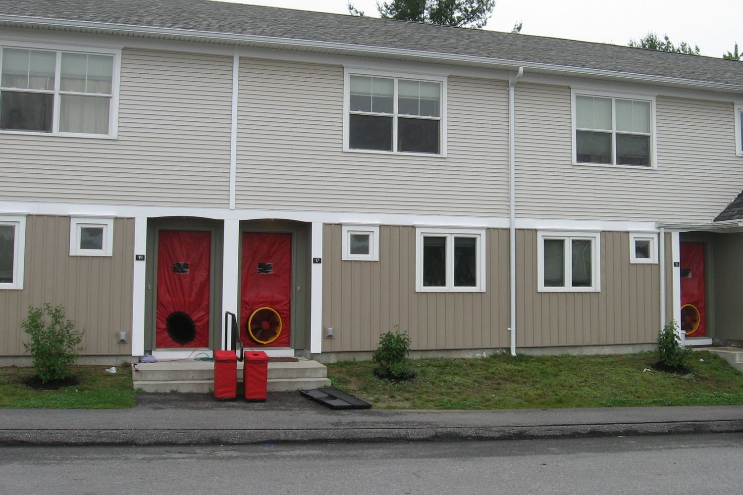 Blower door fans set up on apartment entry doors for an air leakage test