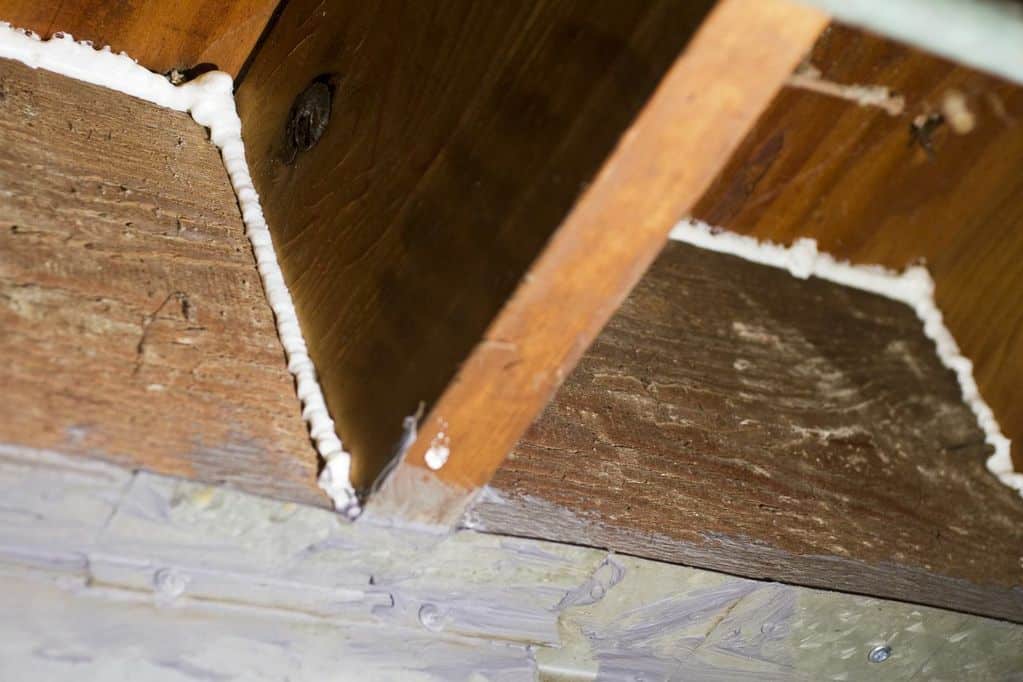 Spray foam at the rim joist Closed-cell spray foam sealing joist bays at a rim joist
